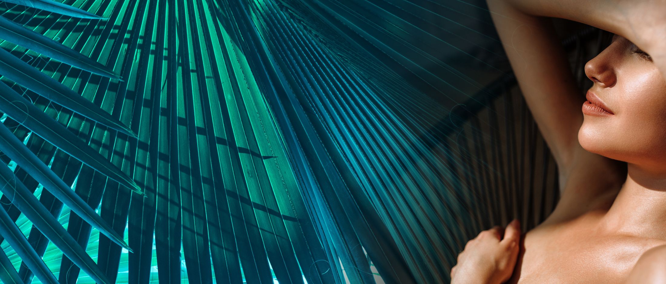Woman relaxing under tropical palm leaves.