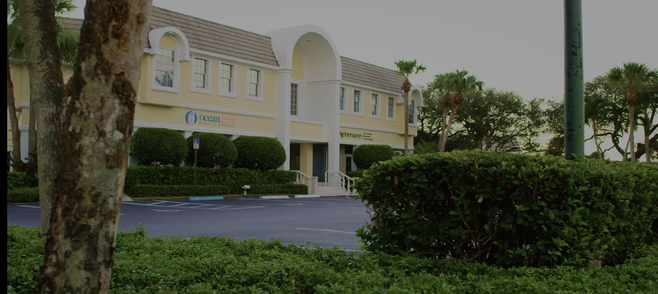 Plastic surgery clinic exterior with greenery.