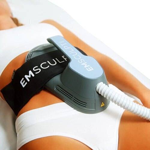 Woman undergoing EMSCULPT body sculpting treatment.