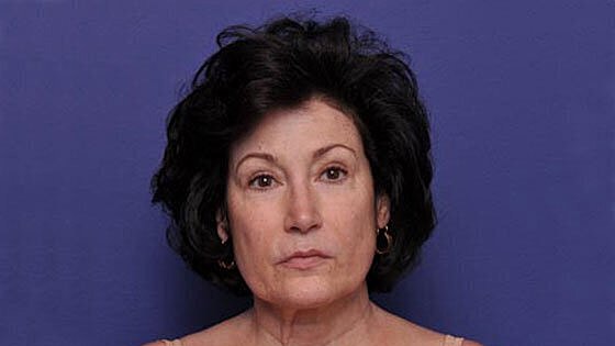 Woman with dark hair against a blue background.