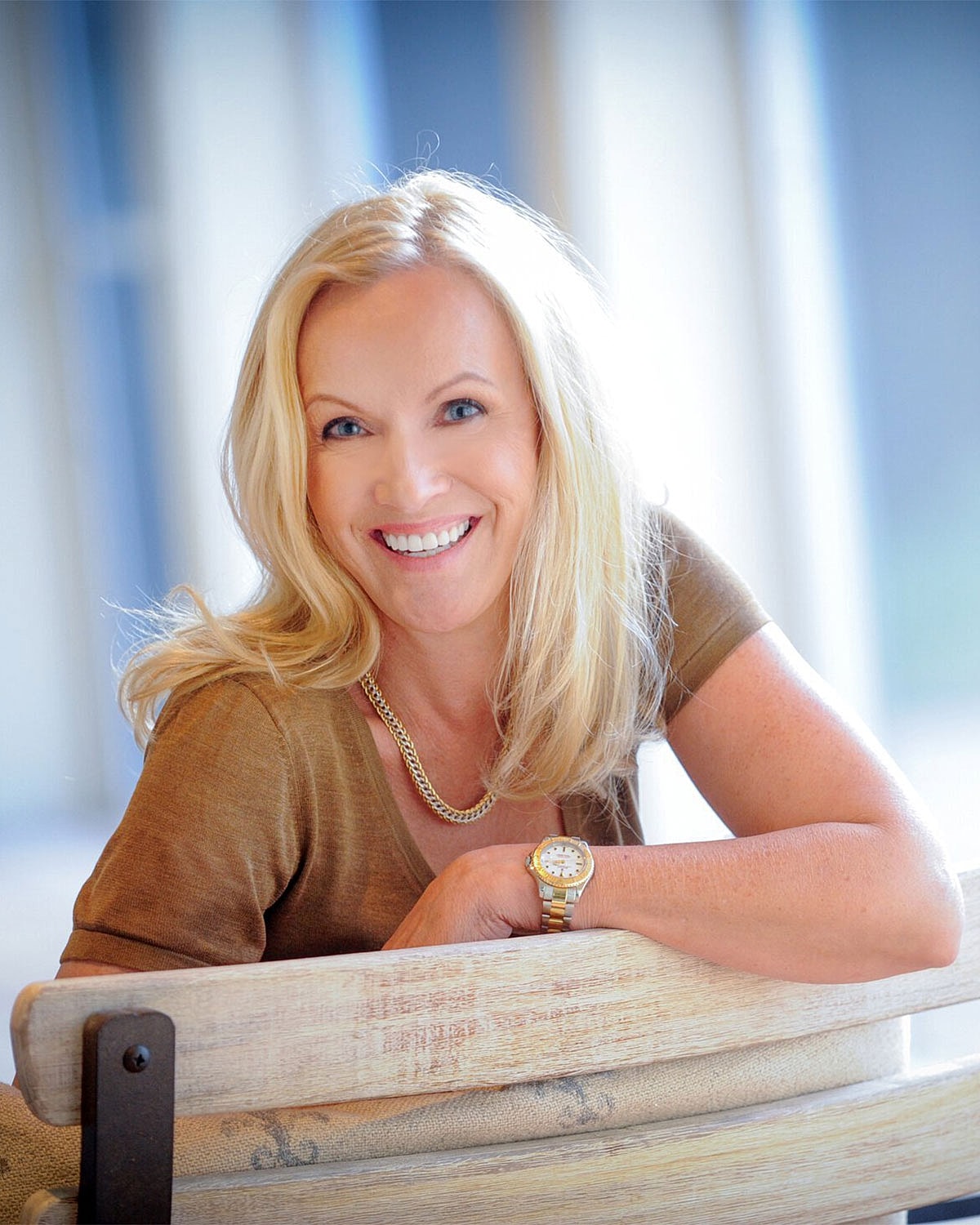 Smiling woman in stylish dress, arms crossed.