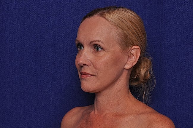 Woman with blonde hair against blue background.