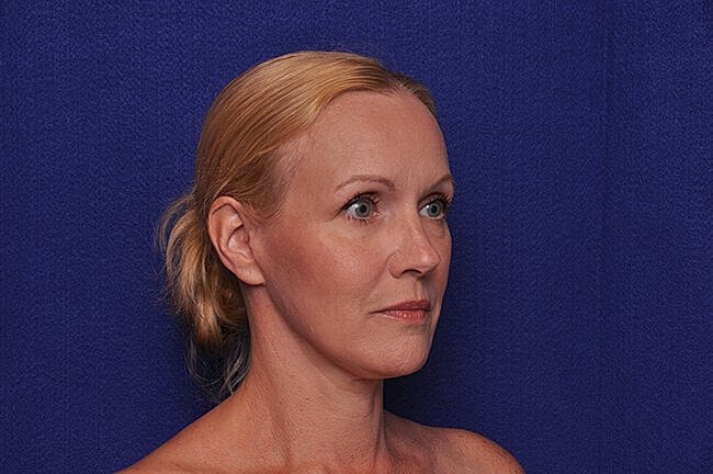 Profile of a woman against blue background.