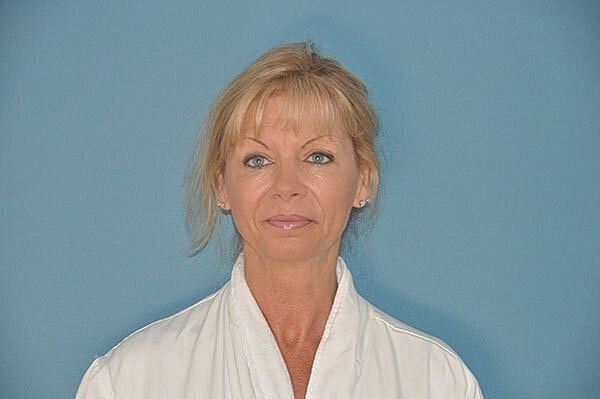 Woman in white robe, blue background.