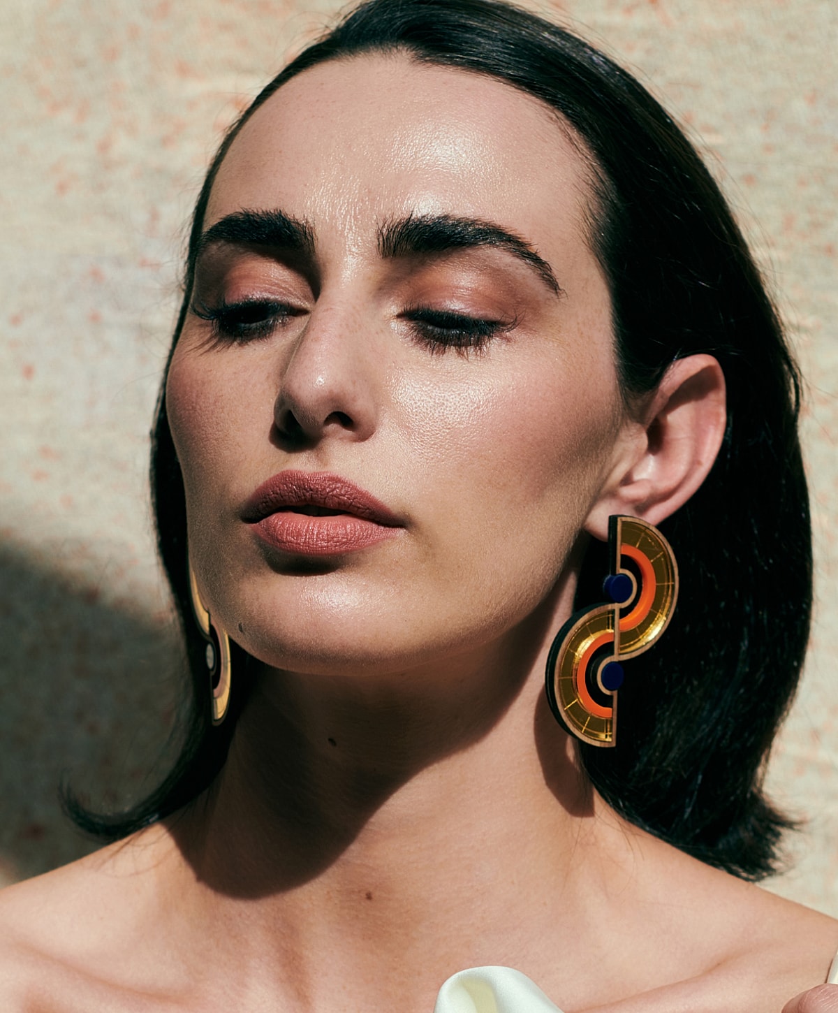 Woman wearing colorful statement earrings.