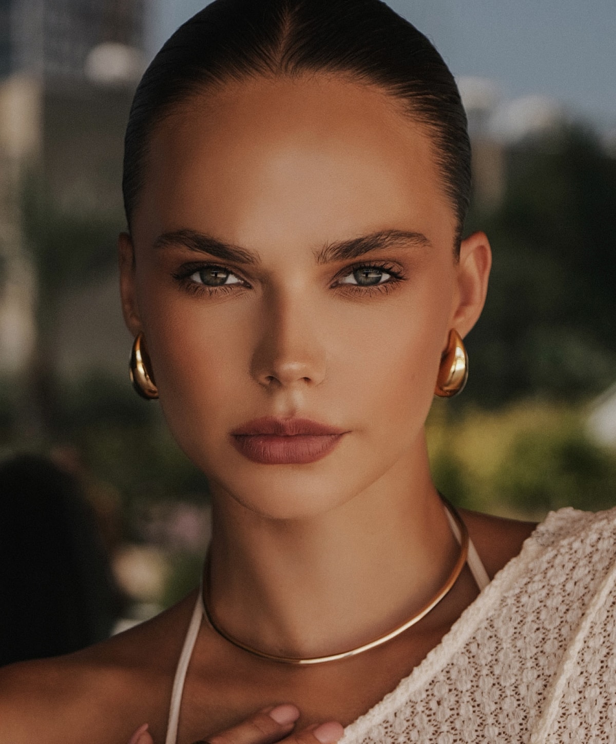 Woman with elegant jewelry and neutral makeup.