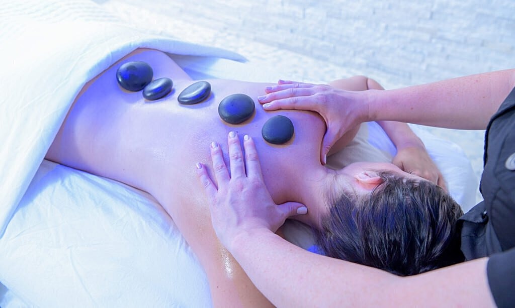 Hot stone massage therapy session in progress