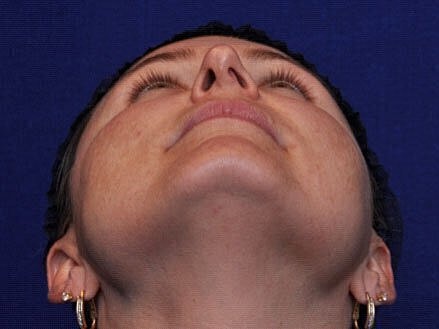 Woman looking upward against a blue background.