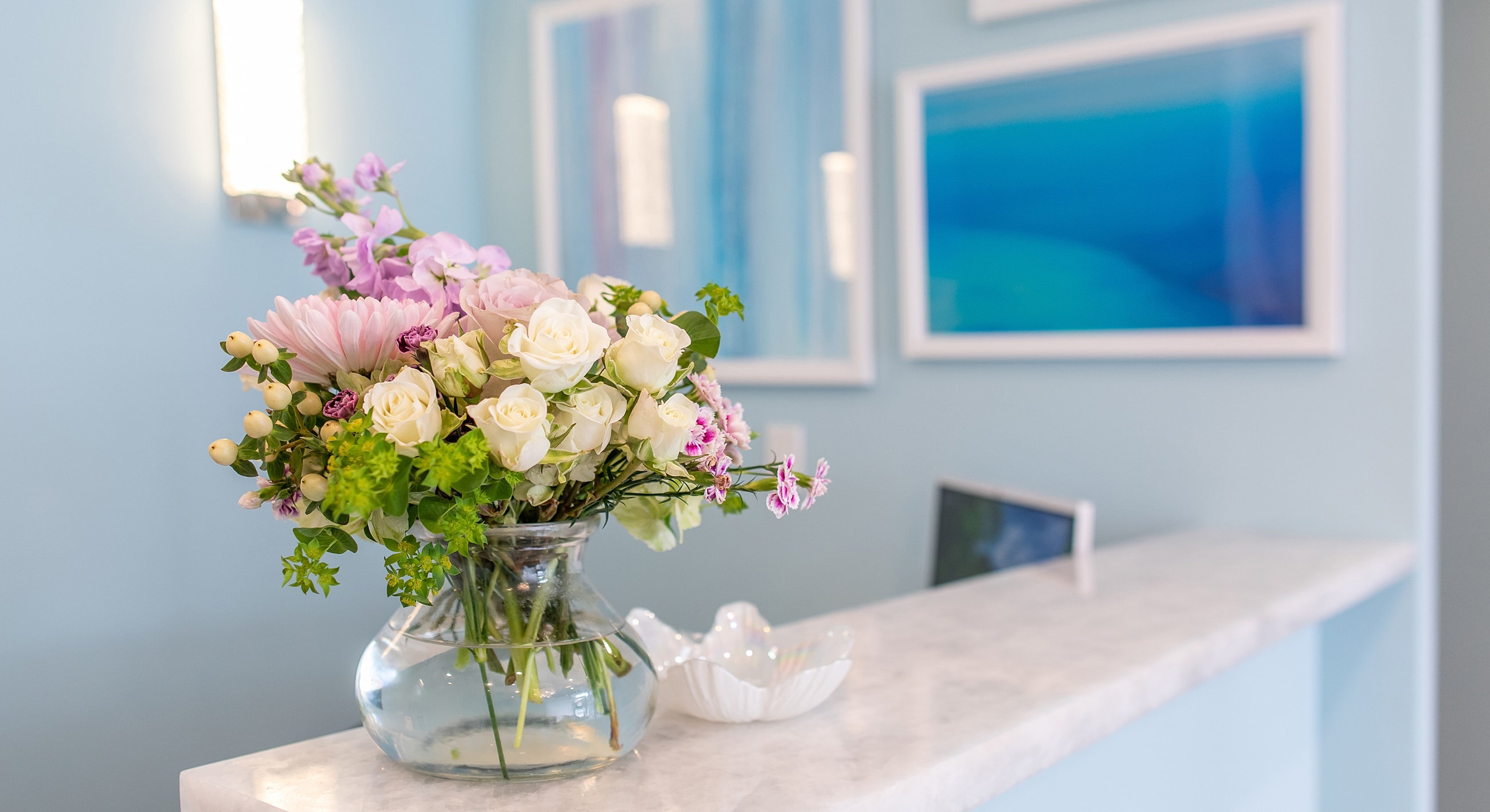 Vase of fresh flowers on marble countertop.