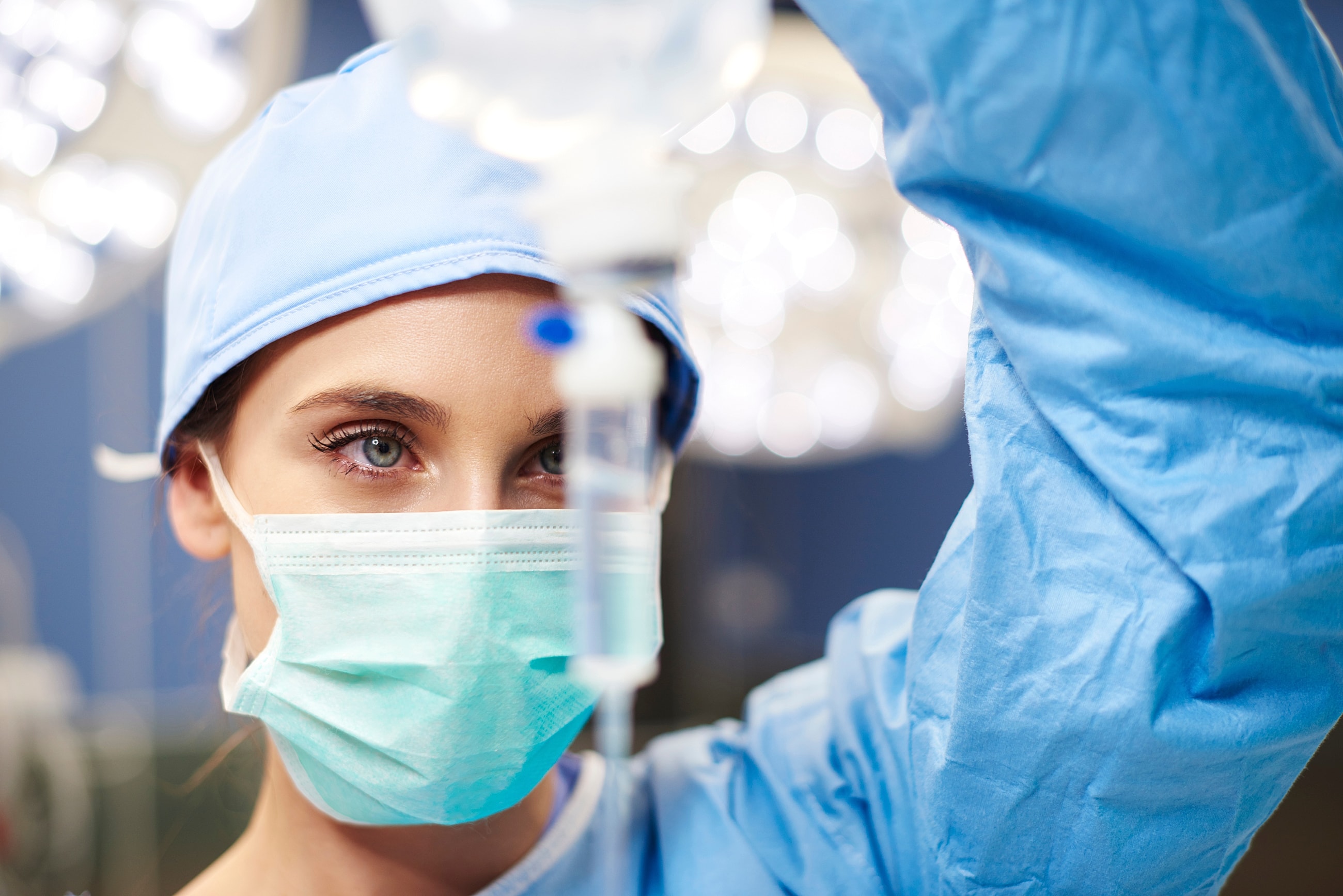 Medical professional preparing an IV drip safely.