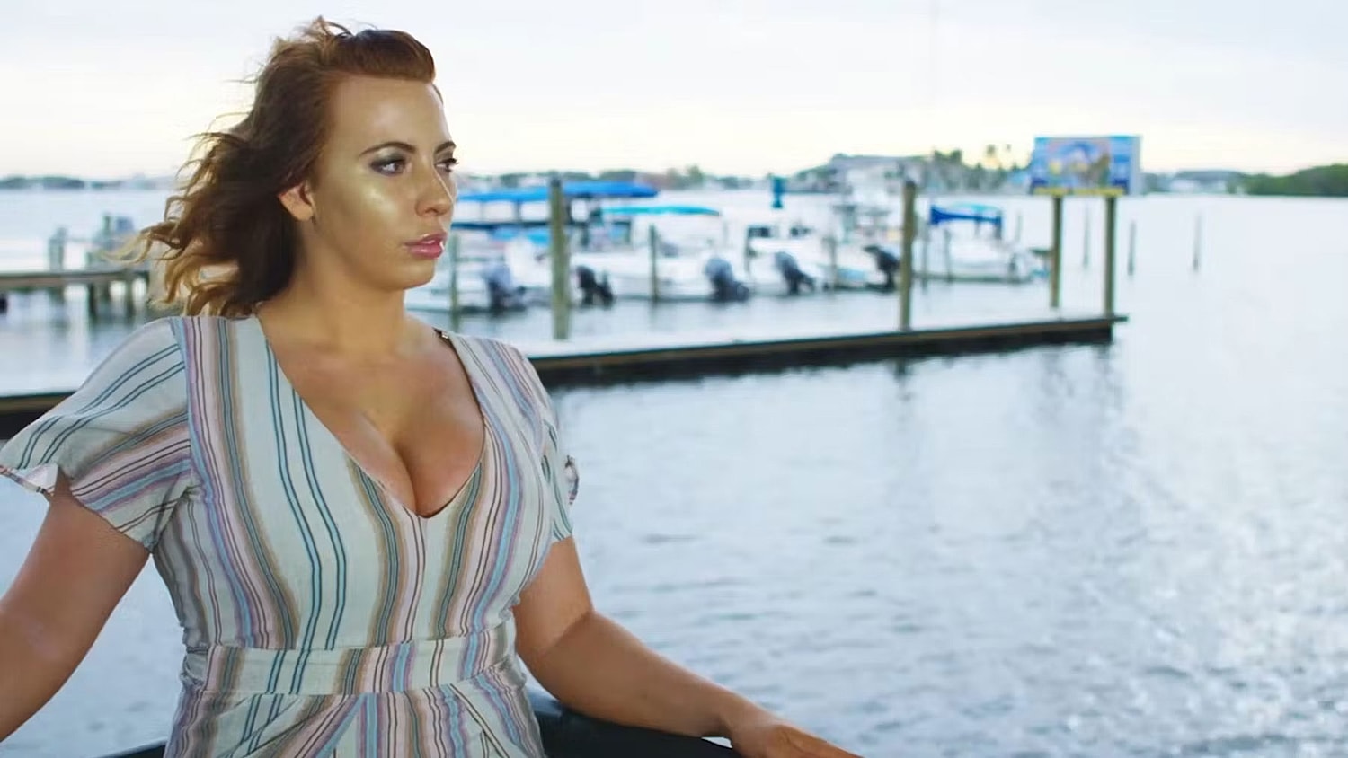 Woman in vibrant swimsuit speaking outdoors.
