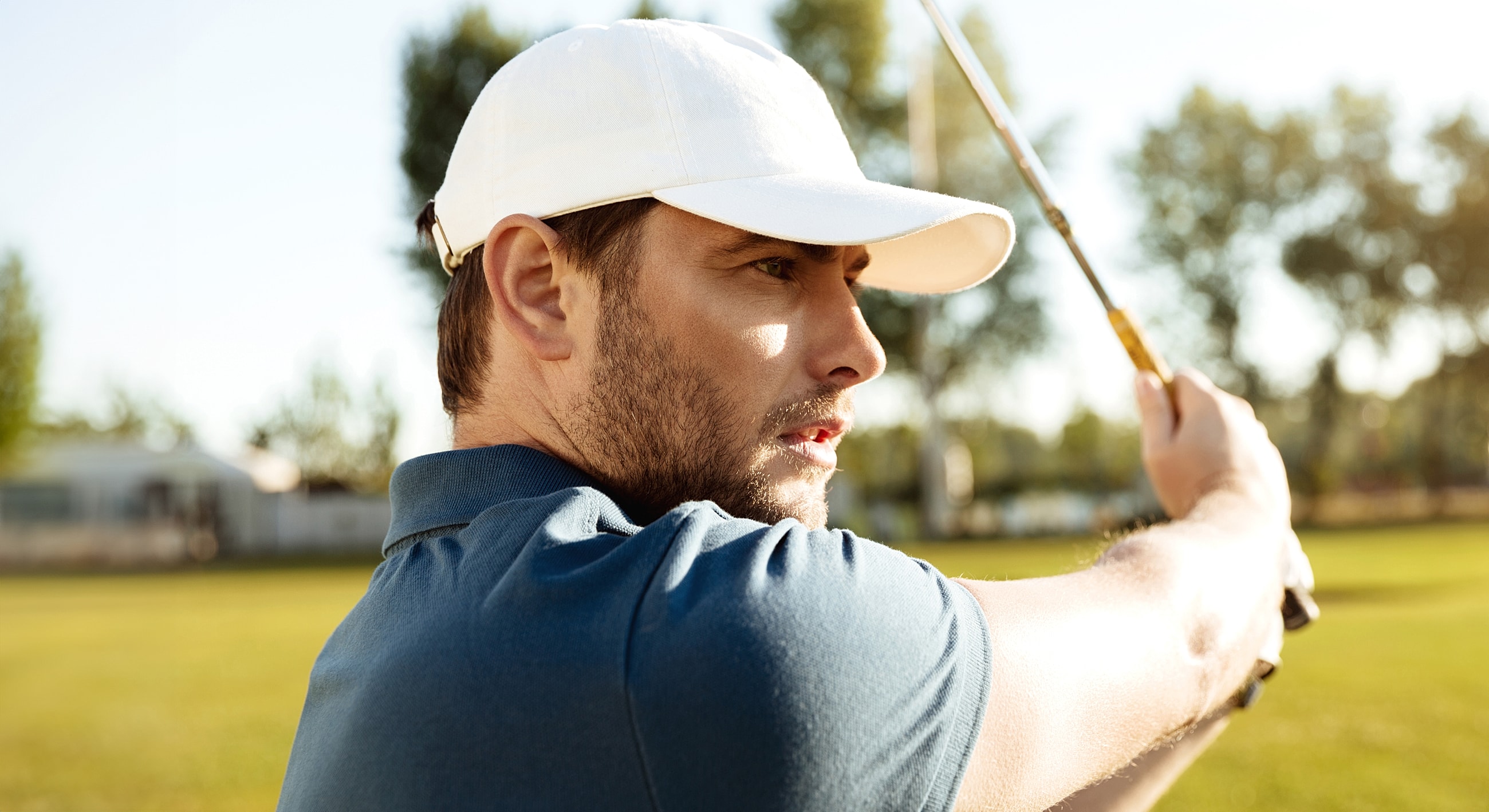 Golfer preparing to swing on a sunny day.