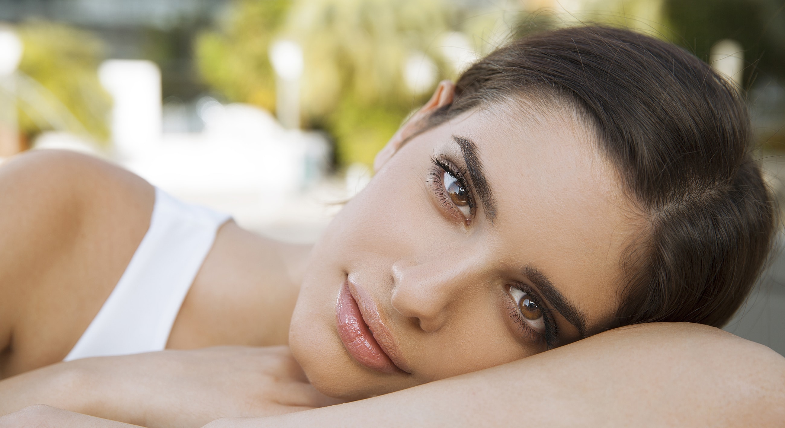 Woman with relaxed expression, outdoors in daylight.